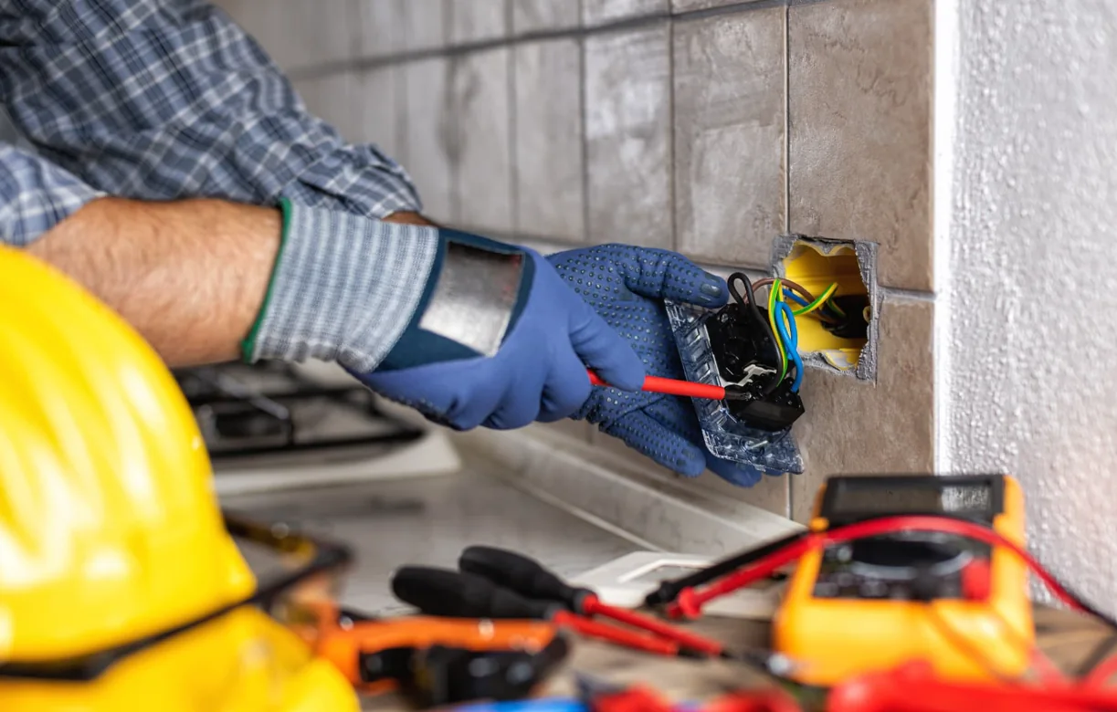 Electricista 24 horas en Madrid reparando el mecanismo de un enchufe en la cocina de una vivienda